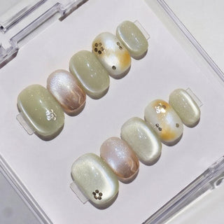 Matcha Made Press-On Nails by EyeCandys: set of 10 handmade nails in glossy marble pale green, white & gold, some with metallic studs—delivers a salon gel manicure look at home. Comes in a clear plastic case.