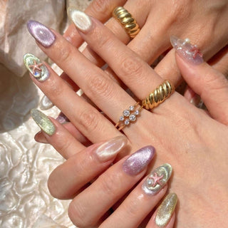Hand wearing EyeCandys Mermaid on Duty press on nails featuring iridescent cat eye glitter nails, 3D starfish, pearl beads, and ocean inspired tones.
