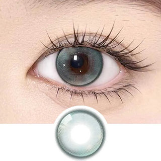 A close-up of an eye wearing a grey contact lens with long lashes is shown. Below, Olola Meow Vivid Havana Green color contacts by Olola are displayed separately, highlighting their vivid design and standout quality among green lenses.