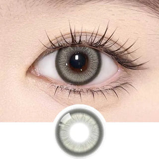 A close-up of a human eye with long lashes wearing Olola Meow Vivid Rubl Green contact lens by Olola. Below the eye, a single prescription colored lens is displayed separately for detail.