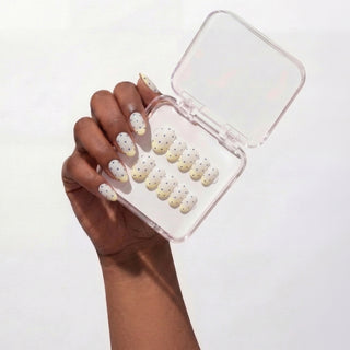 Hand wearing EyeCandys Sunday Dots press on nails featuring pastel yellow French tips and periwinkle polka dots for a soft, cute manicure look.