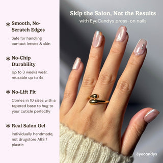 Close up hand showcasing Soft Spoken press on nails with pearly nude pink cat eye effect, iridescent chrome tips, and minimal crystal detail.