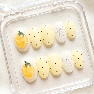 Round press on nails Limoncello with bright pastel yellow tones, 3D lemon nail art, vintage polka dots, and cute bow details for a summer aesthetic manicure.
