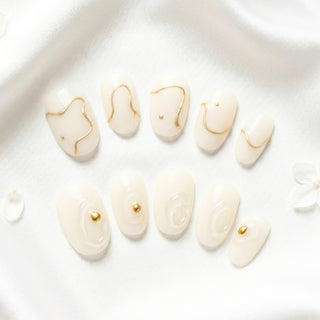 EyeCandys Gilt Lines press on nails featuring sculpted 3D white texture and refined gold accents in a high fashion architectural nail design.
