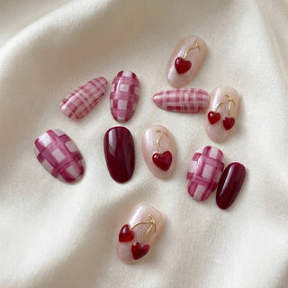 Round press on nails Very Cherry with bold cherry red and fuchsia colors, 3D cherry motifs, and sleek gold detailing for a fun summer manicure.