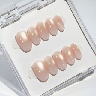 Eyecandys Short oval press on nails Seraphina with blush pink cat eye shimmer and glazed pearl finish for a luminous neutral manicure.