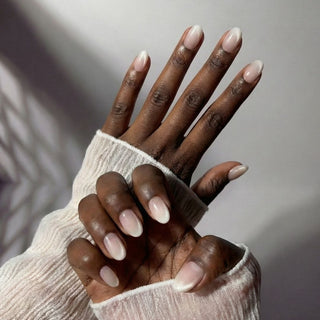Stylish hand wearing Seraphina press on nails featuring minimalist blush pink tones with glowing pearlescent shimmer.