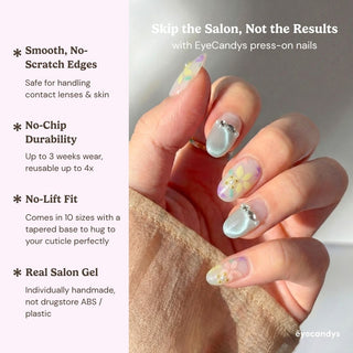 Hand wearing EyeCandys Floreline press on nails featuring soft pastel floral nail art on a sheer milky base with mint shimmer accent.