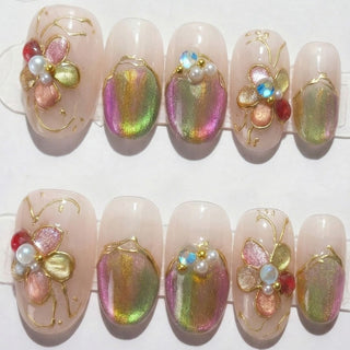 Short oval press on nails Miraflores with iridescent aurora cat eye effect, sheer jelly base, gold wire floral design, and sculpted 3D flower detail.