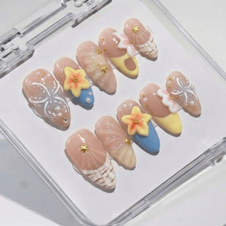 Eyecandys Almond press on nails Shell Yeah with warm nude tones, sculpted conch shell, fan shell detail, pastel wave design, and pearl embellishments.
