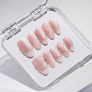 Close-up of EyeCandys Ballet Slippers press on nails in soft nude pink with glossy satin finish, quilted detailing, pearl outlines, and subtle French tip design on a white background.
