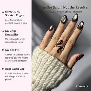 Hand showcasing EyeCandys Midnight Cocoa press on nails with rich dark brown base and shifting blue-grey cat-eye shimmer.