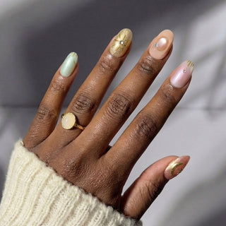 Hand featuring EyeCandys Star Script press on nails with glowing cat-eye base and sculpted celestial symbol accents.