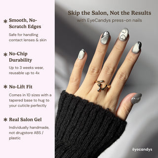 Hand wearing EyeCandys Soft Signals press on nails with soft grey magnetic cat-eye and elegant silver chrome heart details.