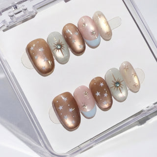 Luxury Space Bar press on nails with copper bronze cat eye effect, pearl blush base, teal starburst accents, and baby blue French tips celestial galaxy nail set.