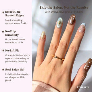 Close up hand with Space Bar cat eye press on nails featuring warm bronze shimmer, pearl blush base, teal star accents, and luxury celestial nail design.