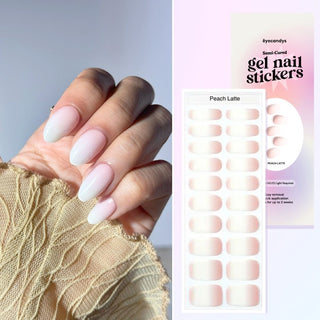  Close-up of hand with EyeCandys Peach Latte Gel Nail Stickers in a beautiful white and peach ombre design. Perfect for a chic, effortless manicure that lasts 2-3 weeks, featuring a 7-free, allergy-friendly formula that cures in sunlight.
