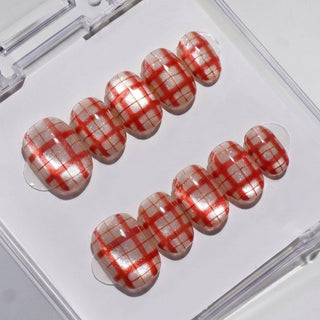 Picnic Date Press-On Nails by EyeCandys feature a glossy white base with a red plaid pattern, neatly arranged in two rows inside a clear plastic box—perfect for achieving a salon-quality gel manicure at home.