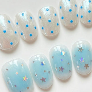 EyeCandys Plot Twist press on nails featuring mismatched design with iridescent white base and blue polka dots on one side, and sky blue jelly with holographic star confetti on the other.