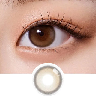 A close-up of a brown eye with long lashes, showing Olola Purity Shine 1-Day Hazel Brown (10pk) contact lens below for comparison. Ideal daily disposable contacts from Olola, available with myopia prescription options.