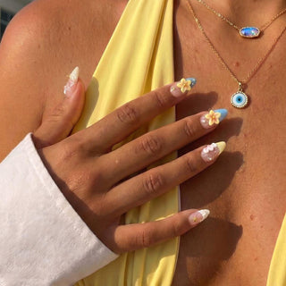Hand wearing reusable Shell Yeah press on nails featuring 3D conch shell, fan shell accents, pearl details, and tropical beach aesthetic.