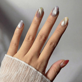 Stylish hand wearing Sorbet Season press on nails featuring bright summer ombre nails and fun dot confetti accents.