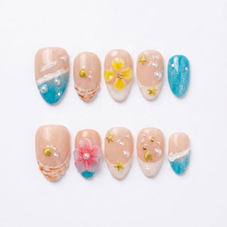Tahiti Feeling Press-On Nails by EyeCandys: a set of 10 reusable handmade nails with beach-inspired designs—blue waves, seashells, pearls, flowers, and gold starfish—on a neutral base for a salon gel manicure look at home.