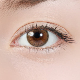 Close-up of eye wearing EyeCandys Topards 1-Day Pearl Cats Eye (10pk) prescription colored contact lens, warm beige haze over light brown iris with soft blurred outer ring, Korean daily disposable contact lens for subtle everyday eye color transformation