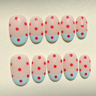 EyeCandys Unbothered Press-On Nails feature a nude base, bright red polka dots, and light blue tips—ideal for achieving a salon-quality gel manicure at home.