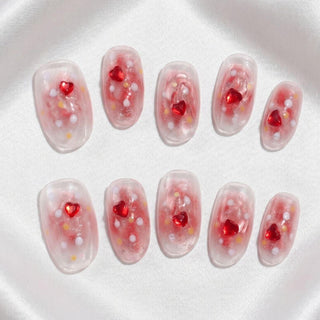 Short round press on nails EyeCandys Catching Feelings with peach jelly base, pink glitter wash, and embedded heart and star confetti.