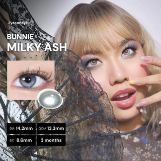 A woman with light blonde hair and colorful nails poses with lace, wearing EyeCandys Bunnie Milky Ash Grey contact lenses. Close-ups highlight the glowy lens design, its details, and a single lens. Text reads "EyeCandys Bunnie Milky Ash Grey.