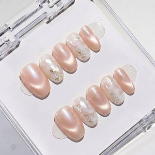 Close-up of Eyecandys Champagne Toast reusable press-on nails showcasing a luminous champagne cat-eye finish, iridescent abalone flakes, and fine silver glitter accents.