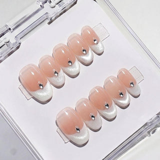 Close-up of Eyecandys Front Row reusable press-on nails showcasing luminous white cat-eye French tips, glossy finish, and sparkling teardrop crystal embellishments.