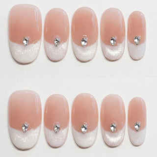 Eyecandys Front Row press-on nails featuring a sheer nude base, glossy white cat-eye French tips, teardrop crystal accents, and a short oval shape.
