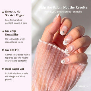 Detailed view of Eyecandys Front Row press-on nails highlighting glossy white cat-eye French tips, teardrop crystal details, and a natural nude base.