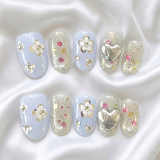 EyeCandys Fleur de Slay press on nails featuring powder blue nails with iridescent glitter, 3D chrome heart, and silver flower clusters with diamante centres.