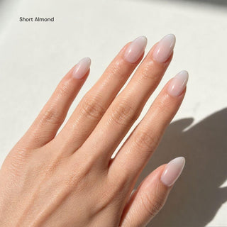 Hand wearing EyeCandys Glazed Donut press on nails featuring soft pink to milky white glazed gradient with glossy clean girl finish.