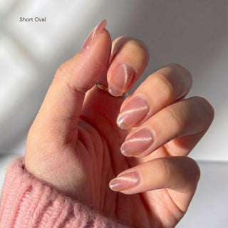 Stylish hand wearing EyeCandys Grapefruit Soda press on nails featuring clean girl pink cat-eye nails with soft gradient glow.