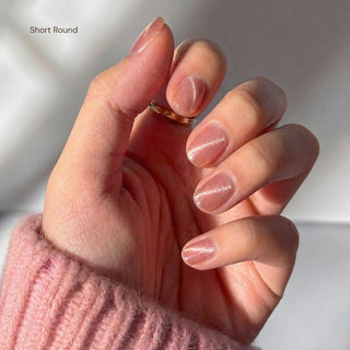 Hand displaying EyeCandys Grapefruit Soda press on nails with sheer grapefruit pink nails and glossy translucent finish.