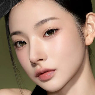 Model with natural makeup and long lashes wearing Eyecandys i-Sha Reborn Olive prescription lenses, highlighting natural olive eye color.