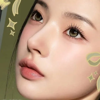 Face of model with natural makeup and long lashes wearing Eyecandys i-Sha Reborn Olive prescription colored contact lenses, showcasing natural olive eye color and comfortable fit.