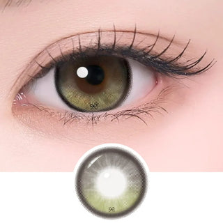 Close-up of eye with long lashes wearing Eyecandys i-Sha Reborn Olive contact lens, showing detailed lens design and natural olive color enhancement.