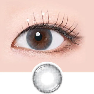 Macro shot of an eye wearing the i-Sha Serenity 1-Day Grey (10pk) prescription colour contact lens, showing the multi-colored detail and natural effect on dark brown eyes, with clean eye makeup. At the bottom is the pattern of the colored lens design, showing the dotted detail and pigmentation.