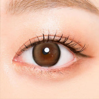 Macro shot of an eye wearing the i-Sha Oriana Mune Brown prescription colour contact lens, showing the multi-colored detail and natural effect on dark brown eyes.