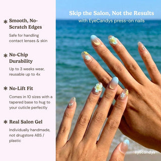Hand wearing EyeCandys Lei’d Back press on nails featuring nude to blue ombre gradient, gold shimmer, and 3D plumeria flower accents.