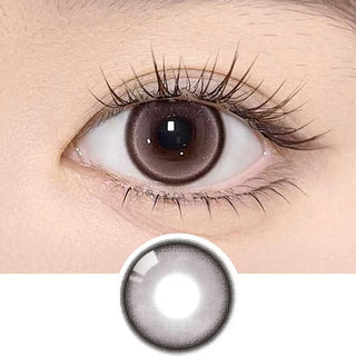 A close-up of a brown eye wearing Olola Meow Natural Angora Pink contacts by Olola, featuring iris-enlarging pink circle lenses and a subtle cat eye effect, with the lens displayed separately below the eye.