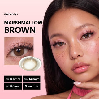 A woman with long brown hair wears EyeCandys Pink Label Marshmallow Brown contact lenses and pink makeup. The image highlights her eye, the natural color, and product details: DIA 14.5mm, G.DIA 14.3mm, B.C. 8.6mm—perfect for everyday wear.
