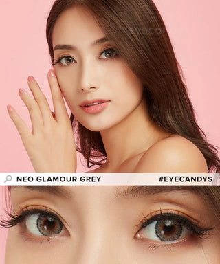 A woman with long brown hair poses against a pink background, highlighting her brown eyes wearing NEO Vision Glamour Grey (Custom Toric for Astigmatism) contacts by NEO Vision. Text reads "NEO VISION GLAMOUR GREY #EYECANDYS.