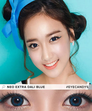 A smiling woman with a blue ribbon in her hair wears NEO Vision Extra Dali Blue contacts by NEO Vision. Her makeup is natural, shown in a close-up of her sparkling blue eyes. Text reads "NEO Vision Extra Dali Blue" and "#EYECANDYS".
