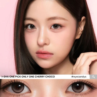 A woman with long dark hair and flawless skin poses by a pink background. A close-up shows her brown eyes enhanced by i-Sha One Pick Only One Cherry Choco lenses. Text: "i-Sha #eyecandys".